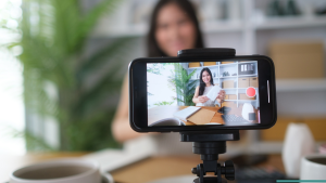 Content creator filming a product video with a smartphone and simple at-home setup.